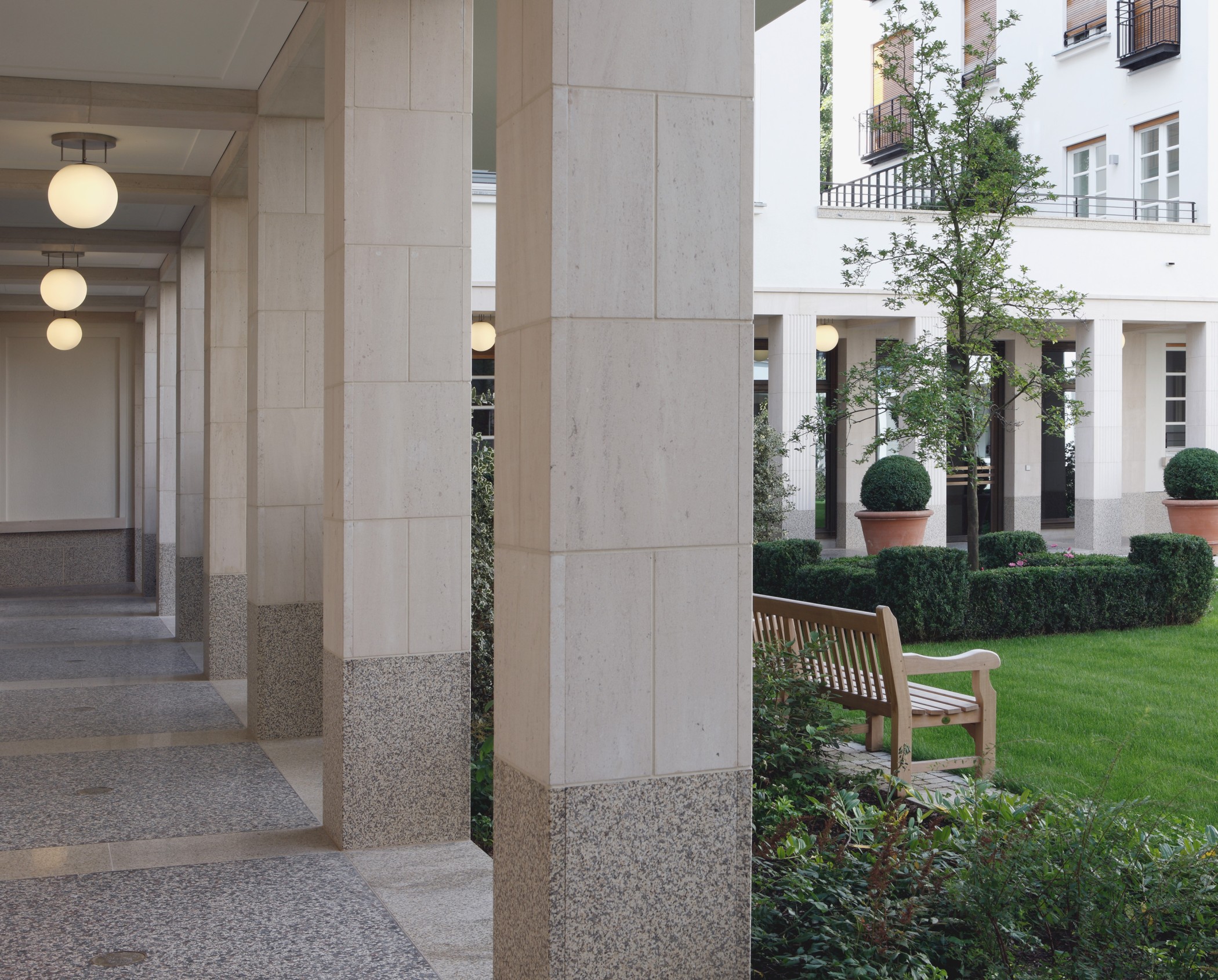Innenhof mit grüner Parkanlage und Springbrunnen im exklusiven Wohnquartier Lenbach Gärten München