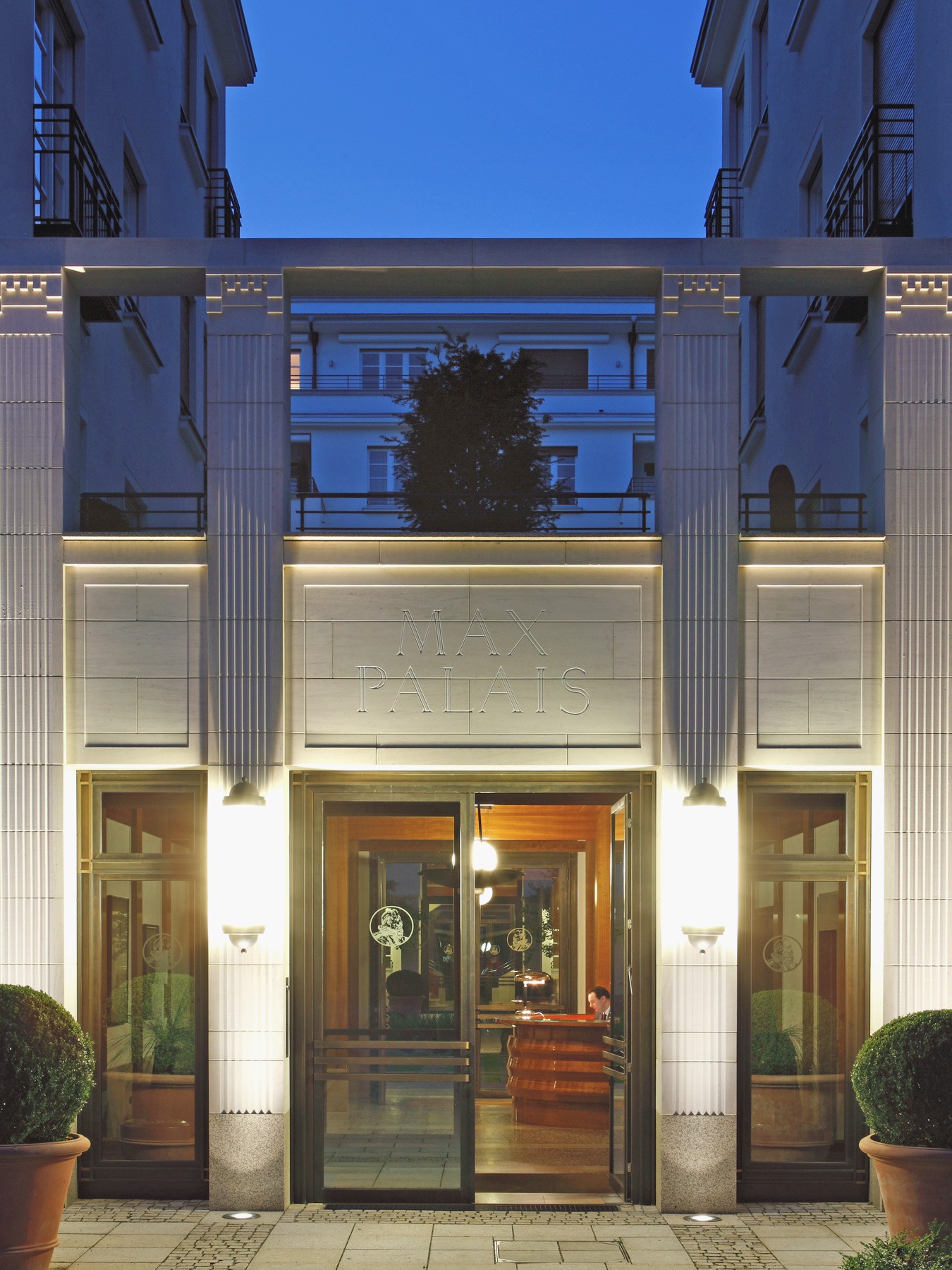 Eingang beleuchtet bei nacht der Lenbach Gärten in München mit Concierge-Service