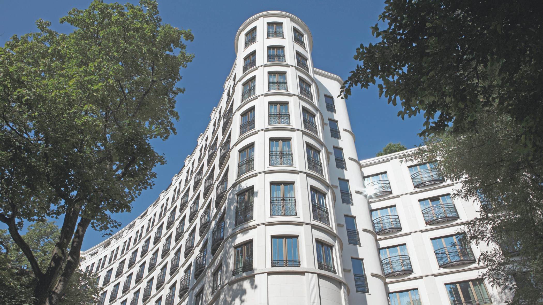 Aufsicht auf die Rundung der moderne Fassade des Charles Hotels im Wohnquartier Lenbach Gärten in München