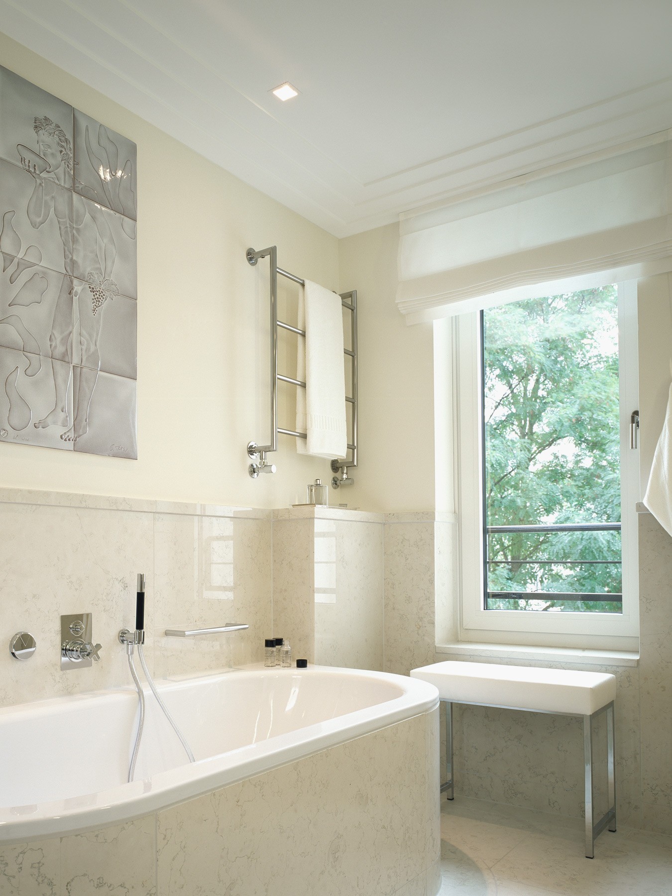 Badezimmer mit hochwertigen Steinfliesen und Ausblick im exklusiven Wohnquartier Lenbach Gärten in München