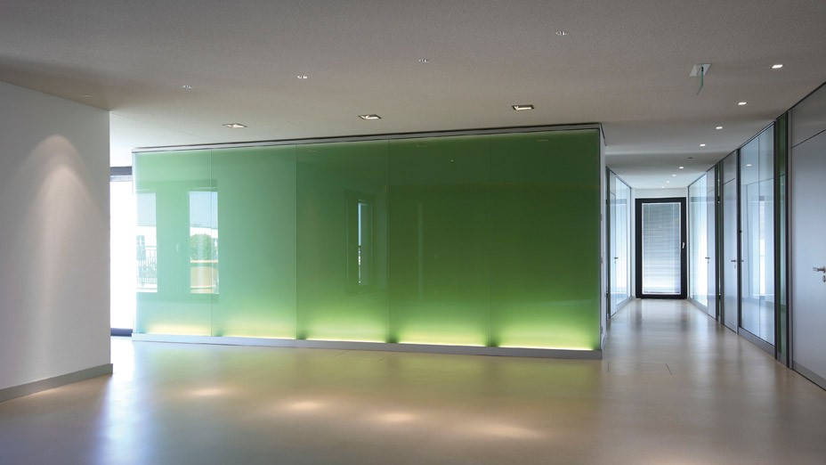 Lobby des Bürogebäudes mit beleuchteten Grünen Glaswänden in den Lenbach Gärten in München