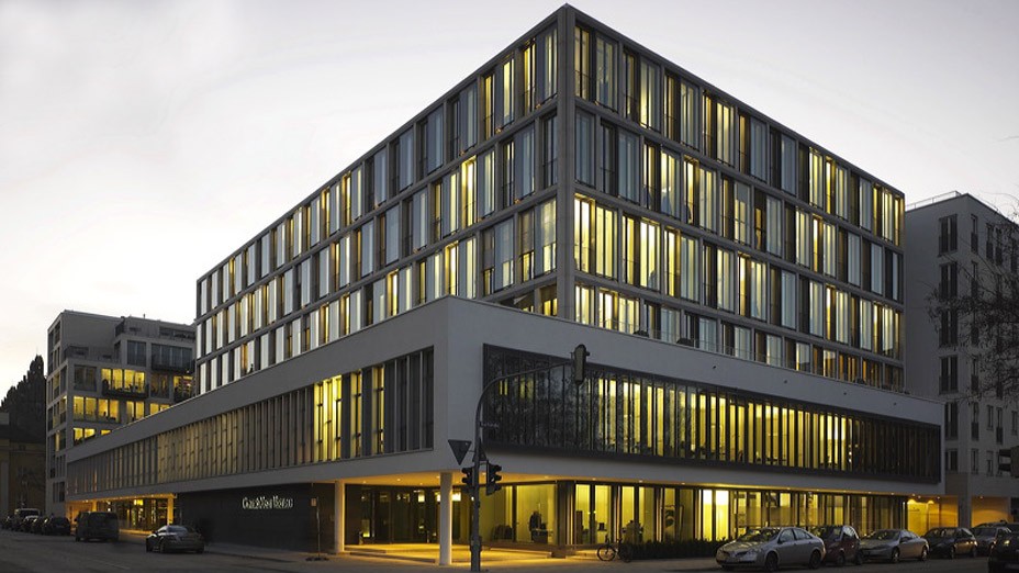 Fassade  des Bürogebäudes bei Nacht beleuchtet in den Lenbach Gärten in München