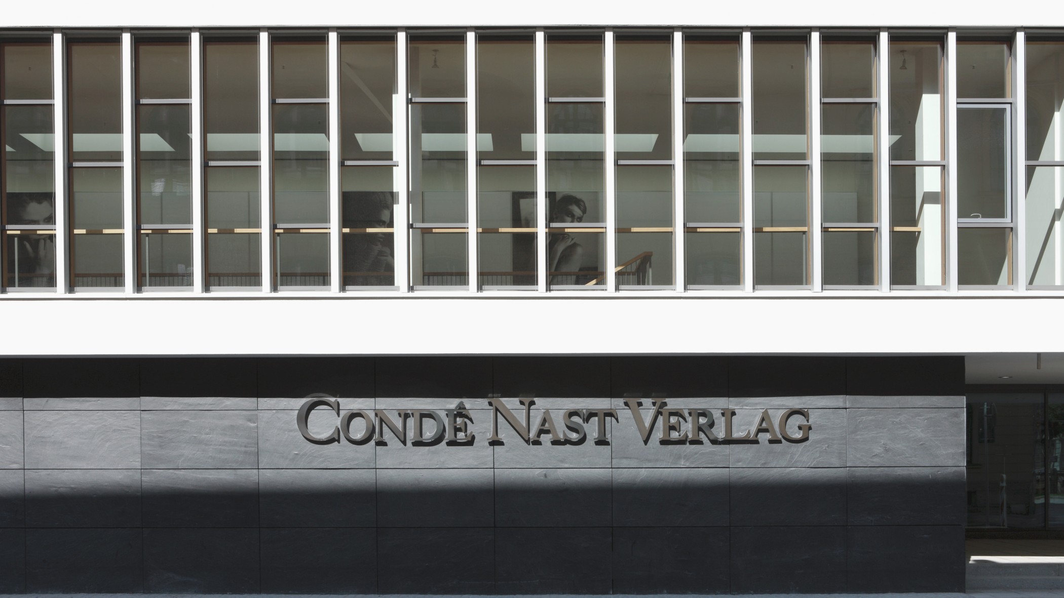 Logo des Cendé Nast Verlags tagsüber am Bürogebäude in den Lenbach Gärten in München