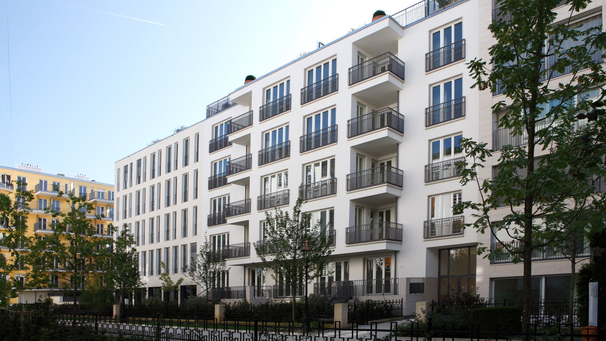 Wohngebäude des Klenze Palazzo mit Balkonen und grüner Parkanlage im exklusiven Quartier Lenbach Gärten München